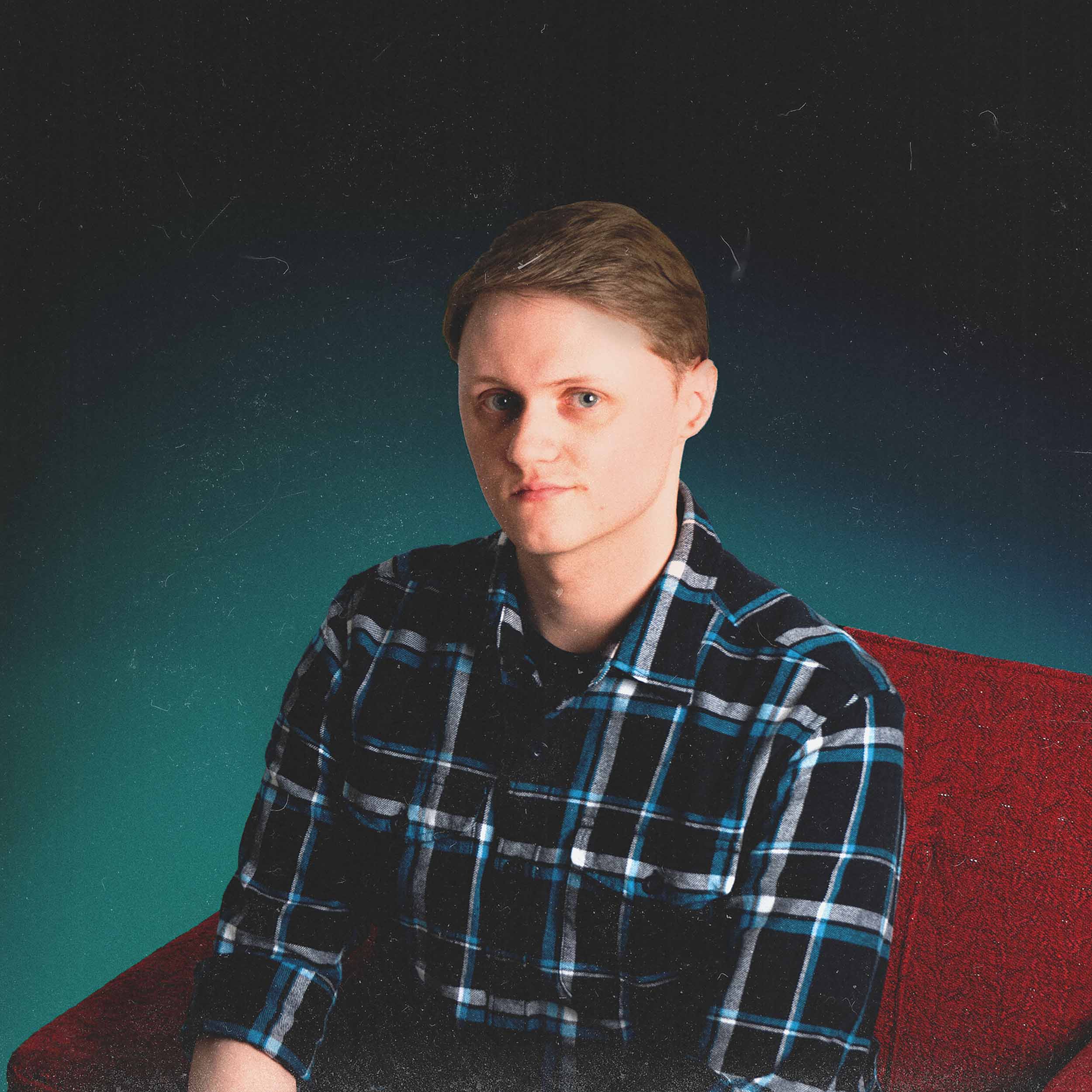 Photo of Kyle DeBeer sitting on a red chair.